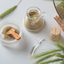 Katari Argil green clay in a hand-blown glass jar beside a frosted mixing bowl and olivewood scoop