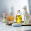Katari Hoba jojoba oil in a hand-blown glass amphora beside an Egyptian Bastet statue