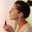 Woman brushing on a green clay masque, the clay step of the Belle Voyaj ritual