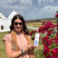 Katari founder Kate holding the Geran box by bougainvillea and white domed houses in the Tunisian countryside