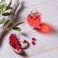 Katari Granate pomegranate seed oil with fresh pomegranate seeds and olive leaves, top view