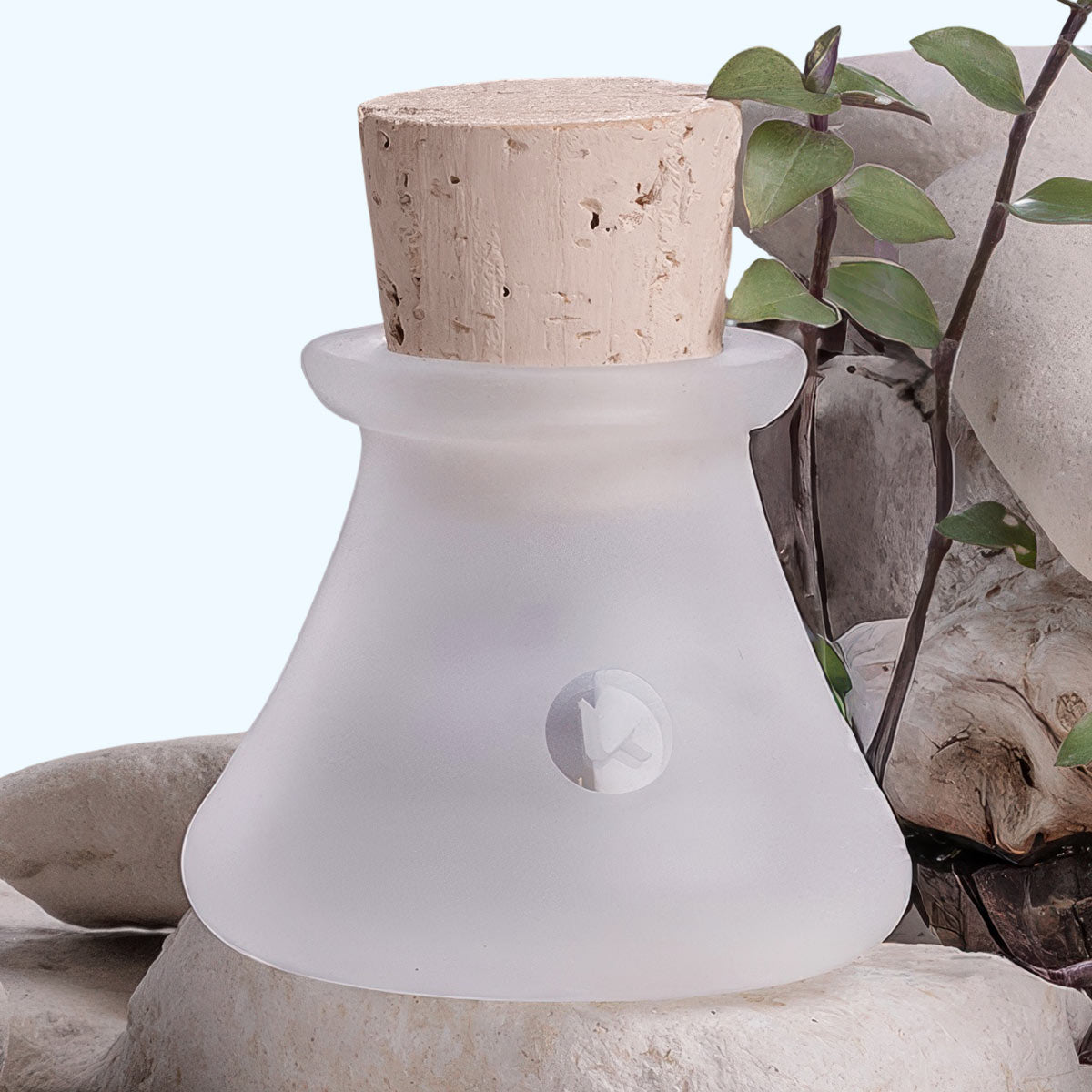 Frosted hand blown glass jar with cork stopper on a natural stone background - 1 oz