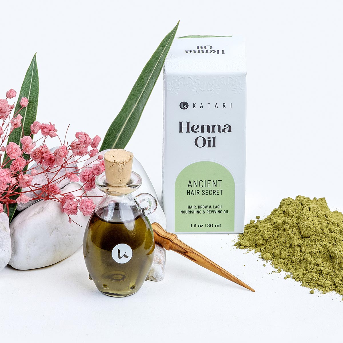 Katari Henna Oil for hair and brow growth with green henna powder and a hand-blown glass amphora on a white background.