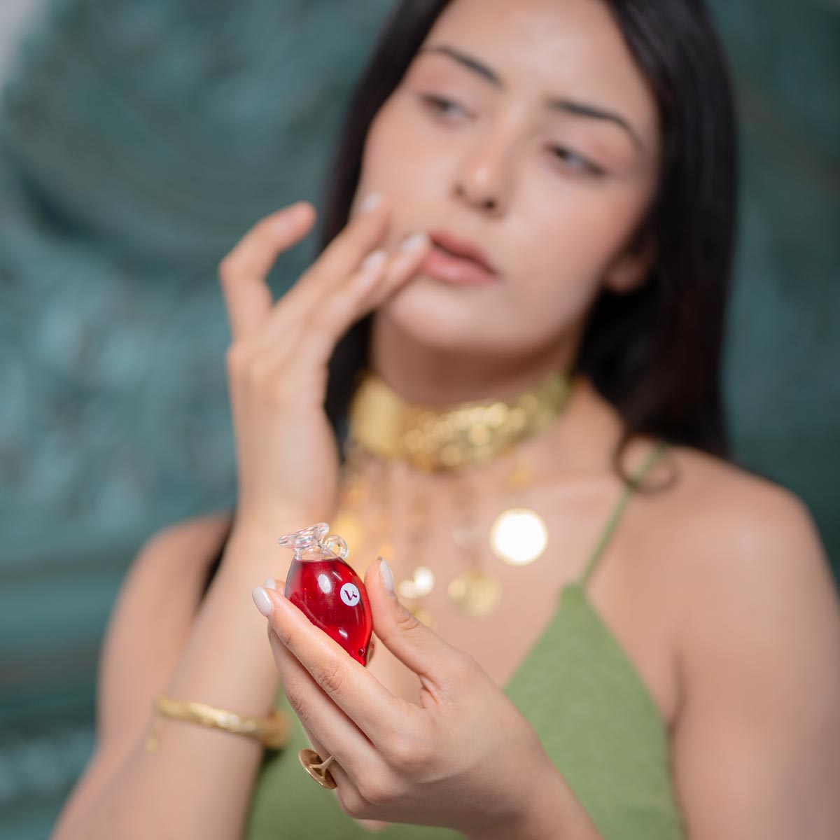 Woman enjoying the scent of Katari Rosehip Oil, 100% pure cold-pressed and rich in Vitamins A & C, in a hand-blown glass amphora.