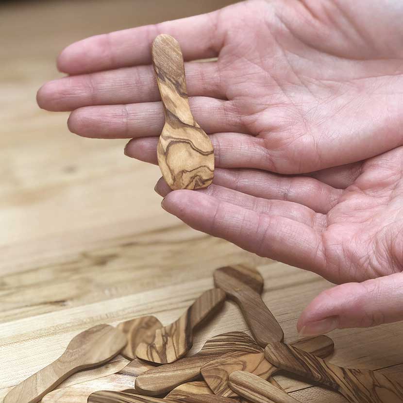 Hand-carved olive wood spatula in the hands